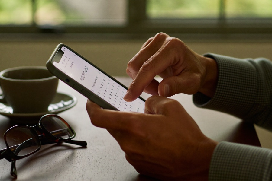 Hände einer älteren Person tippen die erste Nachricht auf dem Smartphone